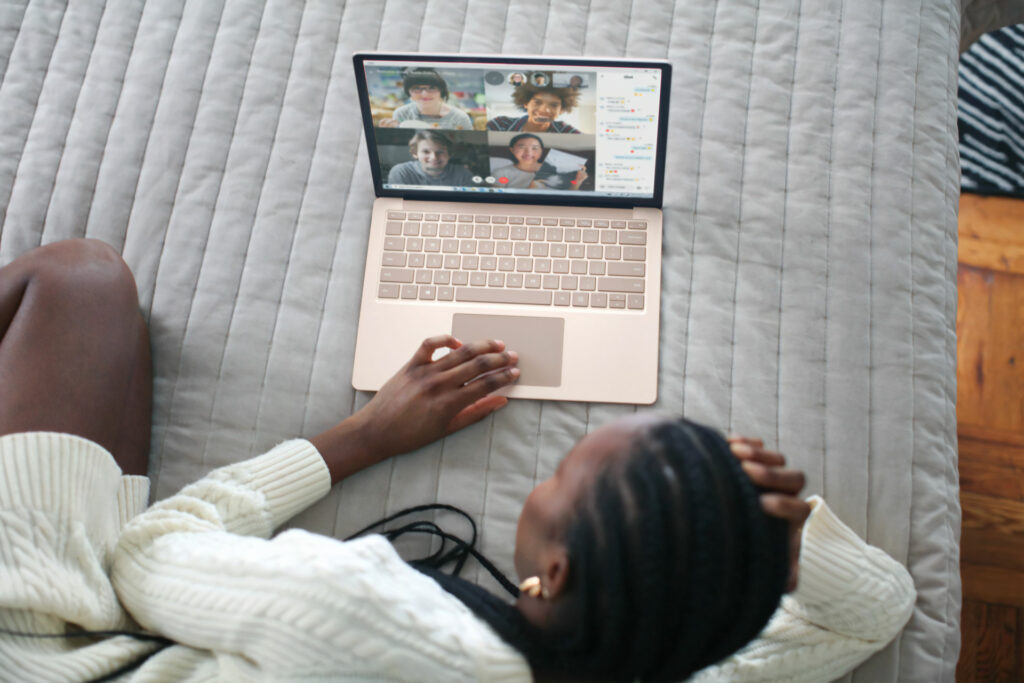 Woman sitting on bed looking at videochat
